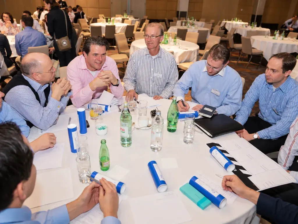 Colleagues around a round table planning their film with scripts and storyboards
