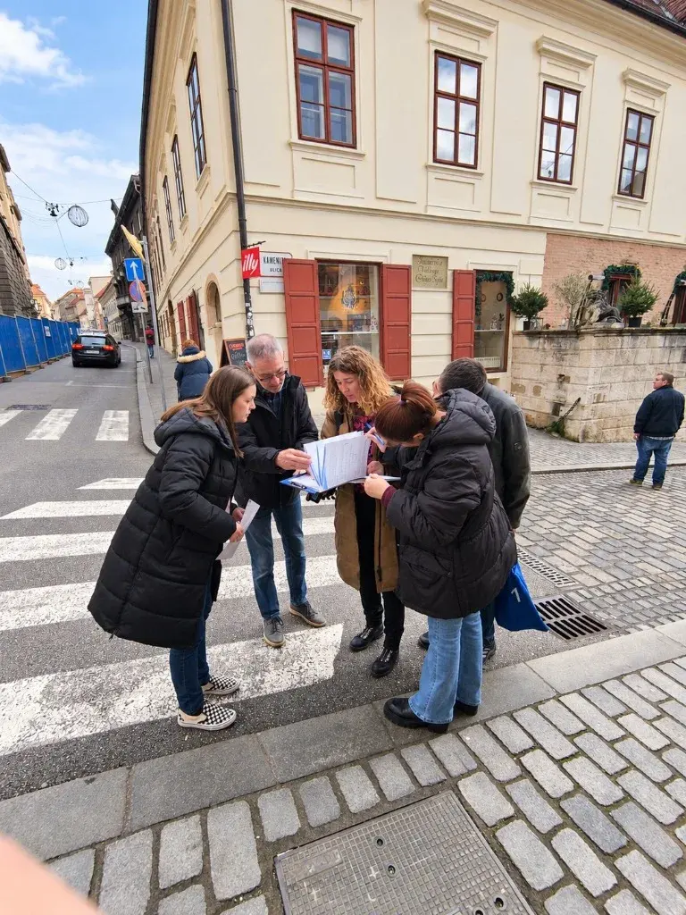 Teammates gathered at a street crossing, reading their challenge booklet
