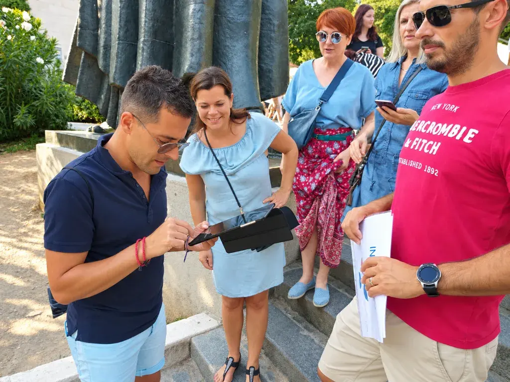 A team member entering an answer on the tablet while colleagues smile and watch